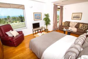 a bedroom with a large bed and a couch at Athens luxurious apartment - sea view! in Athens