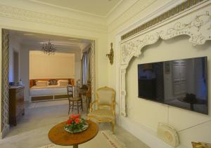 a living room with a tv and a table with flowers on it at Dar ALOUINI in Kairouan