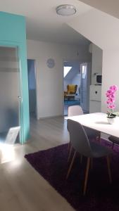 a living room with a table and chairs and a kitchen at Promenad Apartman in Mohács