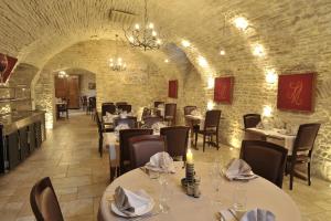 une salle à manger avec des tables et des chaises dans un bâtiment dans l'établissement Le Marius, aux Riceys