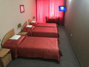 eine Reihe von 4 Betten in einem Hotelzimmer in der Unterkunft Hotel Dunajec in Zgłobice