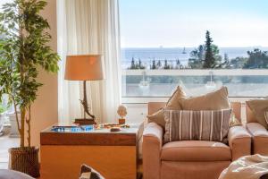 a living room with a couch and chairs and a large window at Athens luxurious apartment - sea view! in Athens