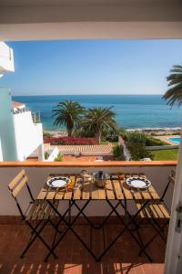 een tafel en stoelen op een balkon met uitzicht op de oceaan bij A29 - Calheta House in Luz in Luz