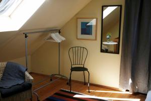 um quarto com uma cadeira e um espelho num sótão em Stenrosgården em Kivik