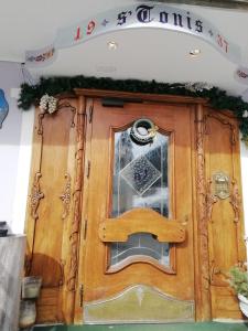 Una porta di legno con un cartello di Natale sopra di ALBERGO SORGENTI DEL PIAVE a Sappada