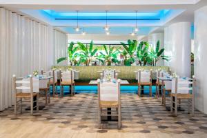jadalnia z białymi stołami i krzesłami w obiekcie Azia Resort & Spa w Pafos