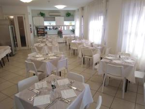 a dining room with white tables and white chairs at Hotel La Bella Vita in Rimini +48 photos