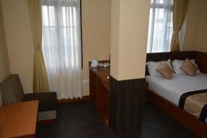Ein Bett oder Betten in einem Zimmer der Unterkunft Juniper Residency Hotel