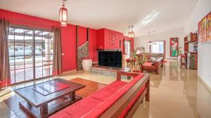 ein Wohnzimmer mit roten Wänden und einer roten Couch in der Unterkunft Villa la senda del majorero in Antigua