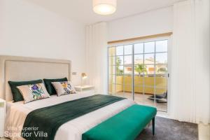 a bedroom with a large bed and a large window at Akivillas Tavira Conceicao in Conceição