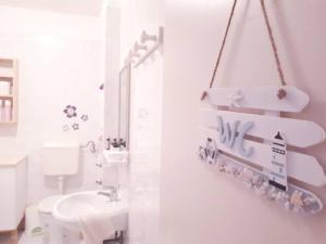 Baño blanco con aseo y lavamanos en House Kate en Rovinj