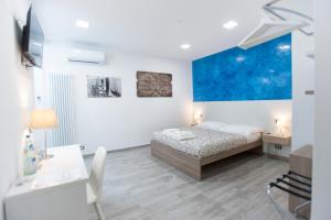 a bedroom with a bed and a table and a desk at MarBianco B&B in Marina di Carrara