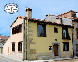 a yellow house with a chimney on a street at La Casa De La Abuela in Ortigosa del Monte