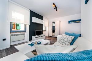 a living room with a white couch and a tv at Studio Biritin in Rovinj