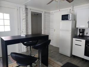 a kitchen with a black desk and two stools at Pirttiniemen Lomakylä in Muurasjärvi