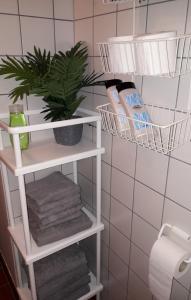 a bathroom shelf with towels and a plant on it at Hamina Orange Apartments Ilves in Hamina
