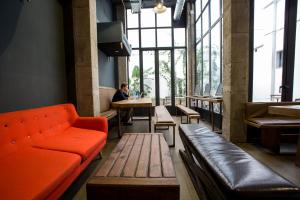 pokój z kanapą i osobą siedzącą przy stole w obiekcie Black Swan Hostel Sevilla w Sewilli