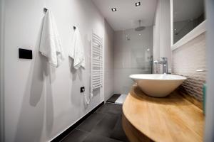 a bathroom with a white sink and a wooden counter at Studio Biritin in Rovinj +46 photos