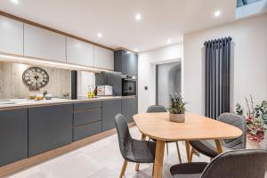 a kitchen and dining room with a wooden table and chairs at King Street Apartment in Norwich