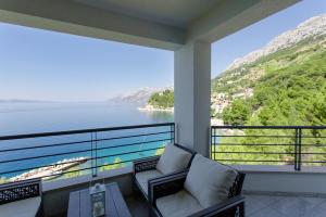 Un balcón con sillas y vista al agua. en Villa Franka, en Brela