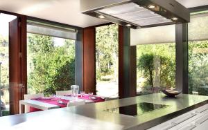 a kitchen with a table and some chairs and windows at Villa Begur Hideaway con piscina privada in Begur