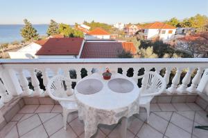 a white table and chairs on a balcony at Villa Vukic in Vrsi