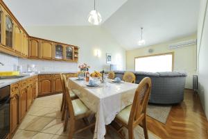a kitchen with a table with chairs and a couch at Villa Vukic in Vrsi