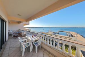 a balcony with a table and chairs and a view of the water at Villa Vukic in Vrsi