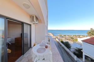 a balcony with a table and a view of the ocean at Villa Vukic in Vrsi