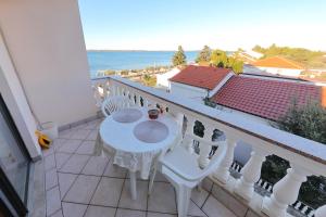 a balcony with a table and chairs and the ocean at Villa Vukic in Vrsi