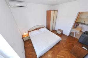 a small bedroom with a bed and a tv at Villa Vukic in Vrsi
