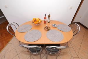 a table with two chairs and a bowl of fruit at Villa Vukic in Vrsi