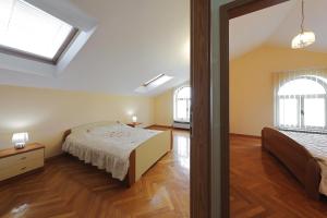 a bedroom with a bed and two windows at Villa Vukic in Vrsi