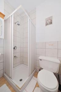 a white bathroom with a shower and a toilet at Villa Vukic in Vrsi