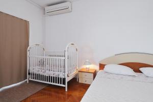 a bedroom with two white cribs in a room at Villa Vukic in Vrsi