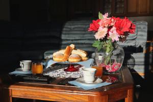 a coffee table with a tray of pastries and flowers on it at Villa Vukic in Vrsi