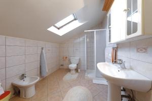 a bathroom with two sinks and a toilet and a window at Villa Vukic in Vrsi