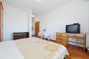 a bedroom with a bed and a tv on a dresser at Villa Vukic in Vrsi