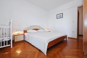 a white bedroom with a bed and a crib at Villa Vukic in Vrsi