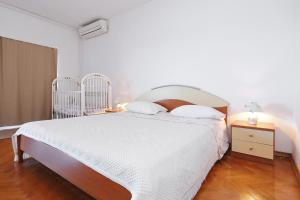 a bedroom with a large white bed and a night stand at Villa Vukic in Vrsi