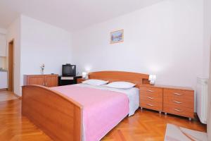 a bedroom with a large bed and a tv at Villa Vukic in Vrsi