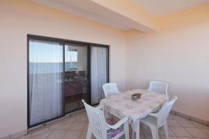 a dining room with a table and white chairs at Villa Vukic in Vrsi