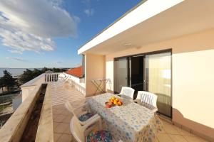 a balcony with a table and chairs and a view of the ocean at Villa Vukic in Vrsi