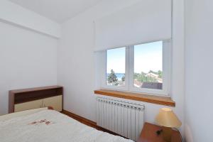 a bedroom with a bed and a window at Villa Vukic in Vrsi