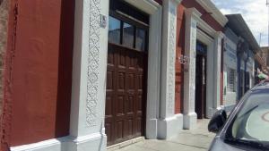 un bâtiment avec des portes brunes sur le côté d'une rue dans l'établissement Hostal Virrey & Tours, à Trujillo