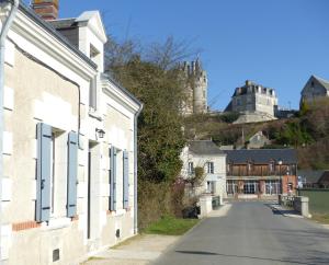 une rue dans une ville avec un château en arrière-plan dans l'établissement La maison de Joëlle, à Châteauvieux