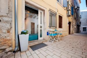 patio con tavolo e sedie su strada di Room Marinata a Rovigno (Rovinj)