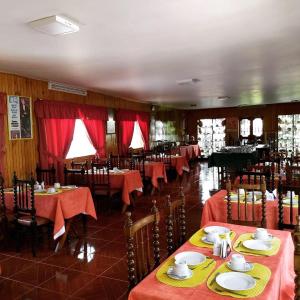 un restaurante con mesas y sillas con mantel rojo en Hotel Colomba, en Huaraz
