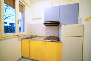 a kitchen with yellow cabinets and a white refrigerator at Villetta 2C in Lido degli Estensi