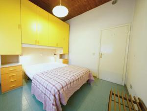 a bedroom with a bed and yellow cabinets at Villetta 2C in Lido degli Estensi